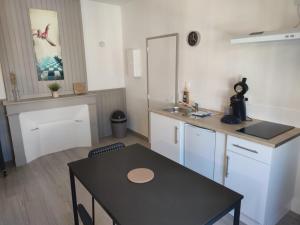 a small kitchen with a table and a sink at *LES STUDIOS L'AMANDINE* in Périgueux