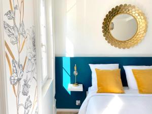 a blue and white bedroom with a bed and a mirror at L'intemporel - Grand T2 climatisé & terrasse in Castres