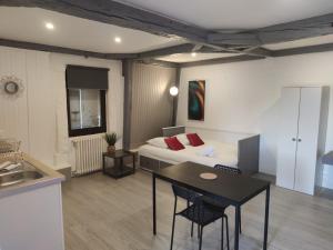 a room with a bed and a table and a kitchen at *LES STUDIOS L'AMANDINE* in Périgueux