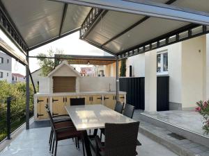 una cocina al aire libre con mesa y sillas en un patio en Holiday Home Romana, en Tribunj