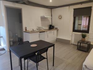 a kitchen with a table and chairs in a room at *LES STUDIOS L'AMANDINE* in Périgueux +8 photos
