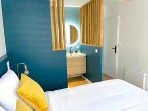 1 dormitorio con cama blanca y lavamanos en L'intemporel - Grand T2 climatisé & terrasse, en Castres