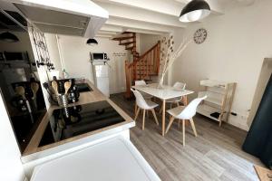 a kitchen and dining room with a table and chairs at Petite maison centre Bourg, 20 min du Puy du Fou in Pouzauges