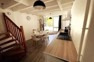 a kitchen and dining room with a table and chairs at Petite maison centre Bourg, 20 min du Puy du Fou in Pouzauges