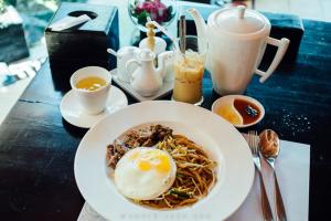 a plate of noodles with an egg on a table at Yaou Hotel in Phnom Penh