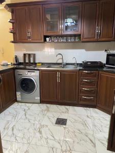 a kitchen with a sink and a washing machine at شقة مفروشة للايجار في عمان شارع الجامعة الاردنية in Amman