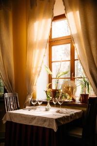 a table with wine glasses on it in front of a window at Pałac Śródka in Chrzypsko Wielkie