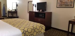 a hotel room with a bed and a flat screen tv at Baymont by Wyndham Harlan in Harlan