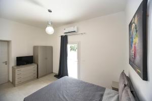 a bedroom with a bed and a tv and a window at Zeituna Lodge a Porto Cesareo in Torre Lapillo