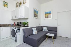sala de estar con sofá y cocina en Dockyard Dreams en Portsmouth