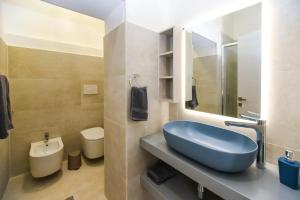 y baño con lavabo azul y aseo. en Zeituna Lodge a Porto Cesareo, en Torre Lapillo
