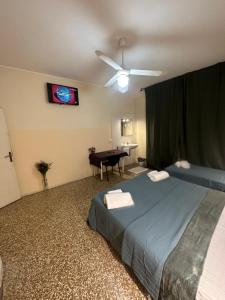 梅斯特的住宿－特倫托旅館，一间卧室配有一张带吊扇和一张桌子的床。