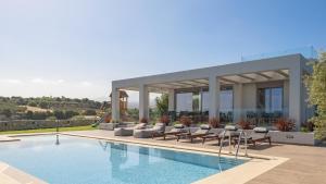 eine Villa mit einem Pool und einem Haus in der Unterkunft Agrielia Villas, featuring Heated Spa Whirlpool, By ThinkVilla in Pigianos Kampos