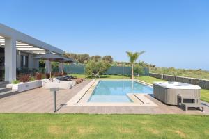 einen Hinterhof mit einem Pool und einem Haus in der Unterkunft Agrielia Villas, featuring Heated Spa Whirlpool, By ThinkVilla in Pigianos Kampos