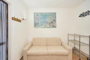 uma sala de estar com um sofá e uma pintura na parede em LA CASA DI LINDA em Porto Ottiolu
