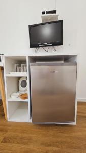 a refrigerator with a flat screen tv on top of it at Vinko rooms in Primošten