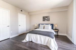 um quarto branco com uma cama grande e pisos em madeira em 3BDR and 2 BTH apt in SM, 5 min to beach with Pool, Gym and Free parking em Los Angeles