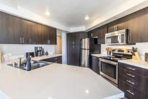 a kitchen with stainless steel appliances and wooden cabinets at 3BDR and 2 BTH apt in SM, 5 min to beach with Pool, Gym and Free parking in Los Angeles