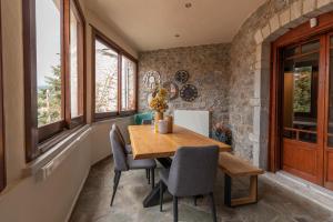 a dining room with a wooden table and chairs at Παραδοσιακός Ξενώνας Βαμβακούς in Vamvakoú