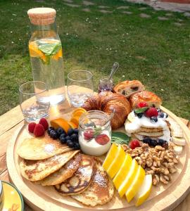 a plate of pancakes and fruit and bread on a table at Hand On Heart , ubytování s jógou in Babice