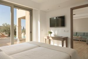 a bedroom with a bed and a television on a wall at Paralos Irini Mare in Agia Galini