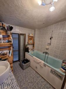 a bathroom with a bath tub and a sink at Typique maison de village in Peille