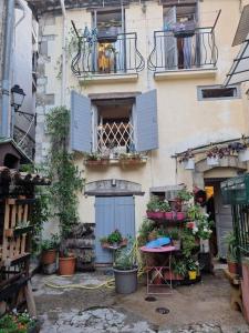a building with blue doors and potted plants on it at Typique maison de village in Peille