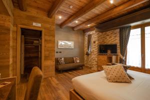 a bedroom with a bed and a couch in a room at B&B San Sebastiano in Vernante