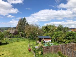 un jardín con una valla de madera y un cobertizo en Ferienwohnung Dörrebach im Soonwald bei Bingen, en Dörrebach