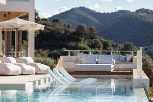 een zwembad met witte ligstoelen naast een zwembad bij Villa Reale in Chania +56 foto's