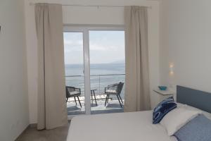 a bedroom with a bed and a view of the ocean at La casa del pescatore in Cala Gonone