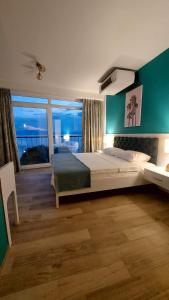 Pier 82 Apartments في أوخريد: غرفة نوم بسرير كبير ونافذة كبيرة