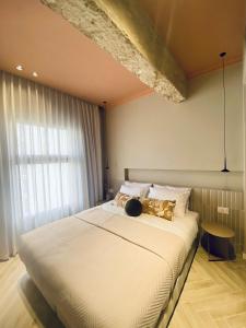 a bedroom with a large white bed with a window at GoodHouse 403 - Pretty Flat near Mamilla in Jerusalem