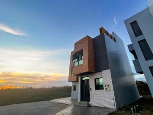 a house on a hill with the sunset in the background at 漁聲民宿 FishON B&B in Magong