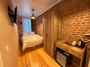 a small bedroom with a bed and a brick wall at Lovely History in Istanbul