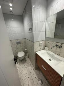 a bathroom with a sink and a toilet and a mirror at GoodHouse 404 - Beautiful 1 Bdr near Ben Yehuda Street in Jerusalem