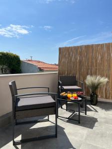 een patio met 2 stoelen en een tafel op een balkon bij Australia in Skiathos-stad