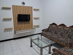 un soggiorno con divano e TV di HASTOSTAY @suryodiningratan a Timuran