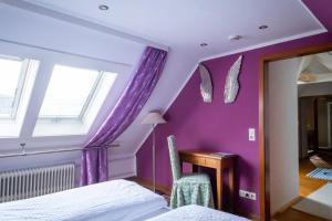 a bedroom with purple walls and a desk with a mirror at NATURION Hotel Hinterzarten in Hinterzarten