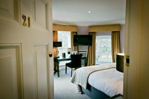 a bedroom with a bed and a desk in a room at Warbrook House Heritage Hotel in Hook