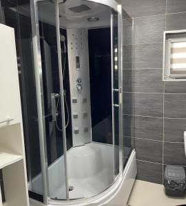 La salle de bains est pourvue d'une douche avec une porte en verre. dans l'établissement Dom nad jeziorem, à Lubkowo