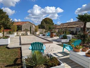 a patio with two chairs and potted plants at EMA Cottage in Montjean
