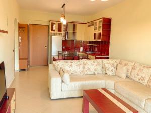 Il comprend un salon avec un canapé et une cuisine. dans l'établissement Beachfront Apartment - Sarandë, à Saranda