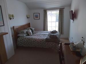 a bedroom with a bed and a window at The Horse and Cart in Peasmarsh