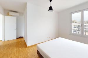 a white bedroom with a bed and a window at Penthouse Albterrassen mit toller Ausstattung! in Waldbronn