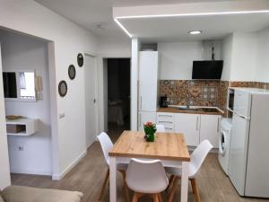 a kitchen and dining room with a wooden table and chairs at Apartamento Margari in Ronda