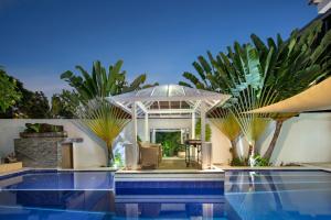 een huis met een zwembad met een parasol bij 3BR Villa Shree Canggu beach - Parking, Wifi & Pool in Canggu