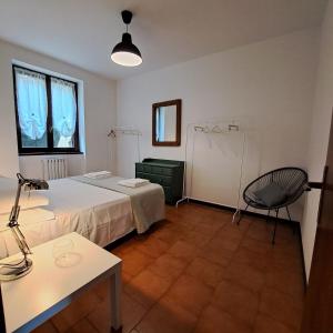 Cette chambre comprend un lit, un bureau et une chaise. dans l'établissement La casa di Guia, à Perledo