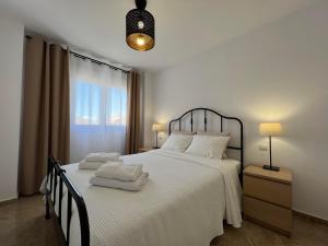 sypialnia z białym łóżkiem i ręcznikami na nim w obiekcie Residence Turiga w mieście Estepona +29 zdjęć