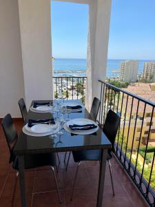 stół z kieliszkami do wina na balkonie z widokiem na ocean w obiekcie Residence Turiga w mieście Estepona
